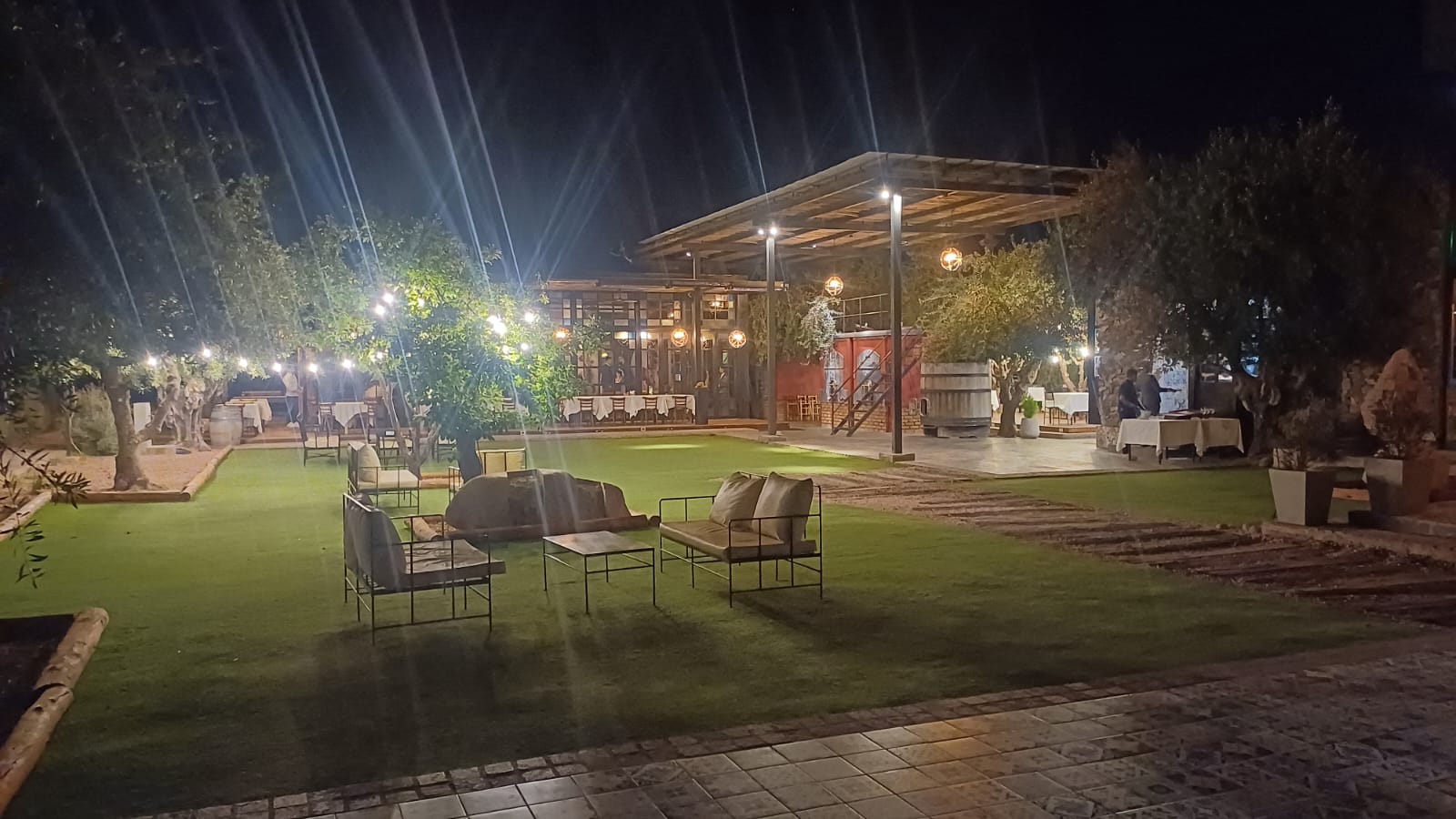 Jardines encantados y detalles artísticos rodean la entrada de Casa Vigil, con una estética mágica inspirada en la Divina Comedia, viñedos al fondo y un ambiente cálido y exclusivo.